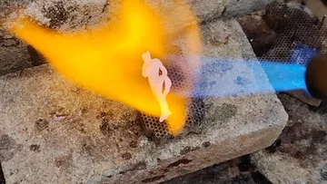 Metallteil, das mit Flammen auf Ziegeln gelötet wird