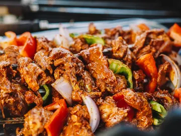 Grilled meat with vegetables on an outdoor plate.