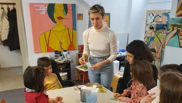Lehrer, der Kinder in einem Kunstunterricht leitet.