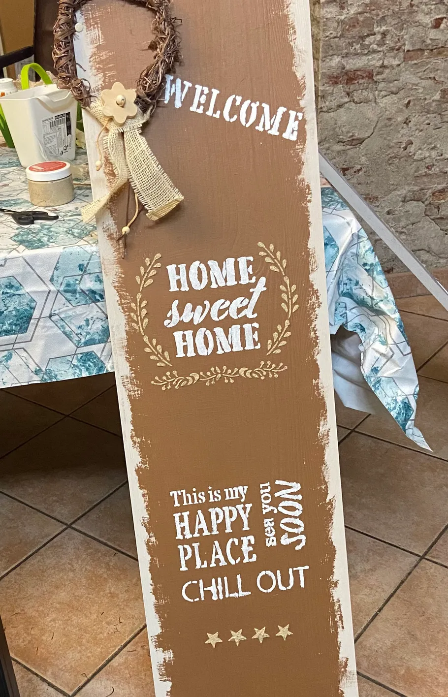 Decorative wooden sign with welcoming text on table.