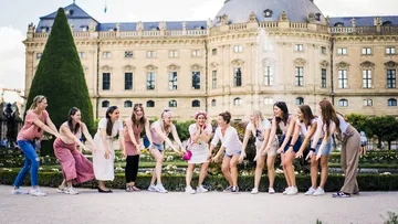 Gruppe von Frauen posiert fröhlich vor einem historischen Gebäude.