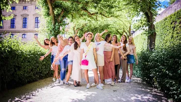 Gruppe von Frauen posiert auf dem Gartenweg.