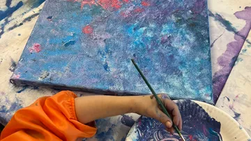 Child painting colorful abstract picture.