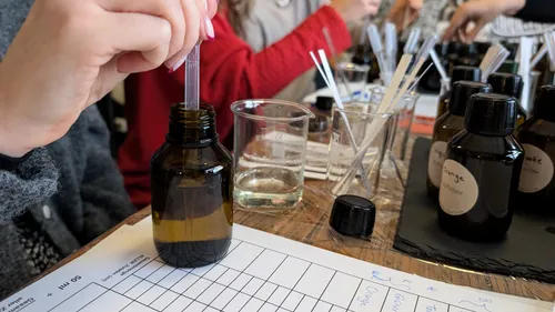 Person mixes liquids in a workshop setting.
