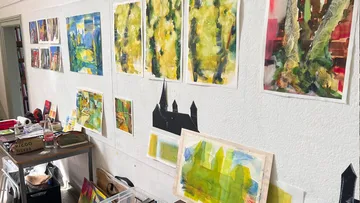 Colorful abstract paintings displayed on a studio wall.