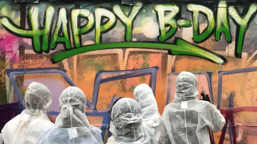 People in white suits spray painting graffiti.