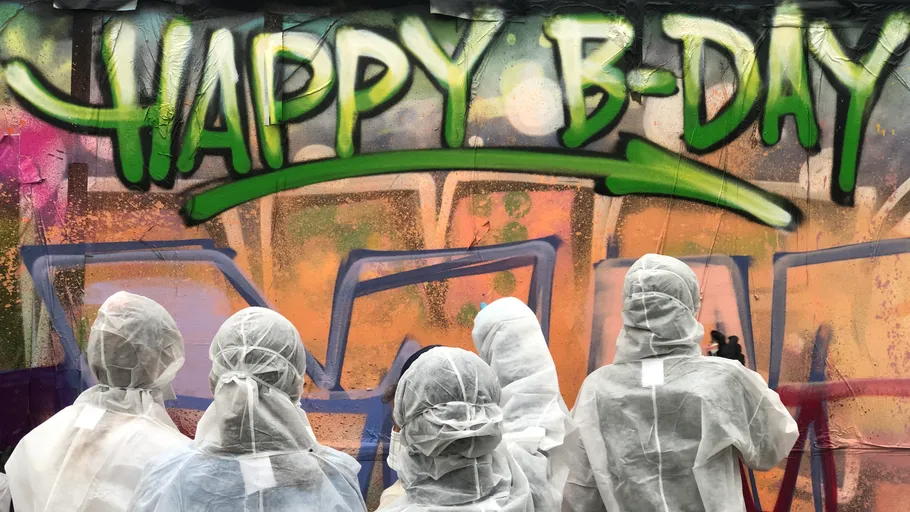 Menschen in weißen Anzügen sprühen Graffiti auf.