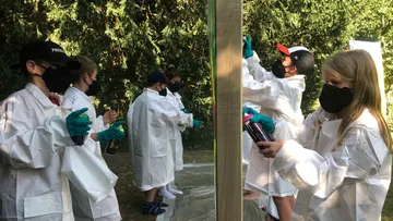 Kinder sprühen im Freien in Schutzausrüstung.