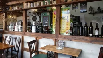 Wooden bar shelves with bottles and mugs.