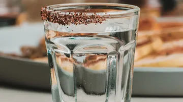 Ein Glas Wasser mit gesalzenem Rand auf dem Tisch.