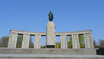 Statue atop memorial with arching columns.