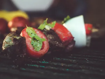 Gegrilltes Gemüse und Fleischstücke auf dem Rost.