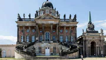Baroque palace with statues and spiral stairs.