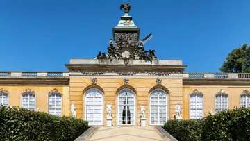 Elegant palace facade with statues, clear sky.