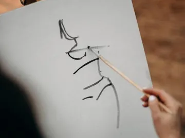 A person draws a figure with a pen.