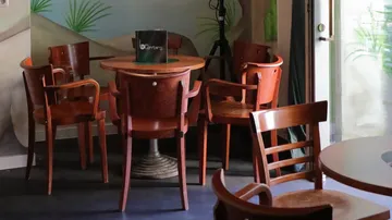 Holzstühle an einem runden Tisch in einem Café.