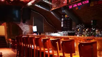 Leere Bar mit Holzstühlen und gedämpfter Beleuchtung.