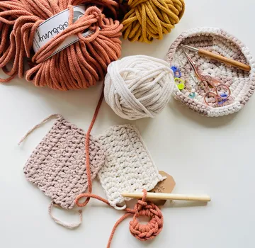 Crochet supplies including yarn, hooks, and swatches.