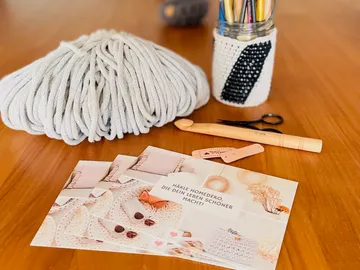 Crochet tools with yarn and instructions on table.