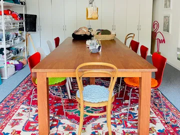Craft room with large table and yarn storage.