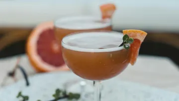 Cocktail mit Orangengarnitur auf dem Tisch.