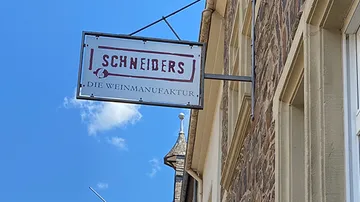 Schild mit der Aufschrift „SCHNEIDERS DIE WEINMANUFAKTUR“ am Gebäude