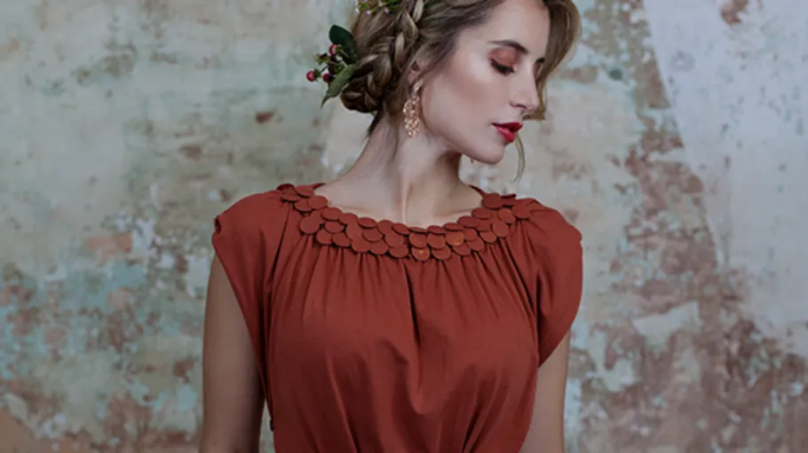 Frau in rotem Kleid mit Blume im Haar.