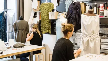 Zwei Frauen nähen in einem Modestudio.