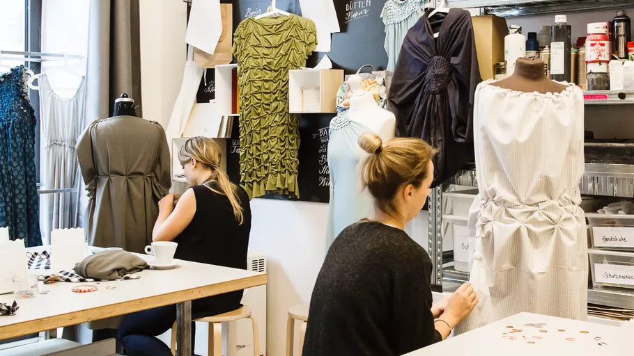 Zwei Frauen nähen in einem Modestudio.