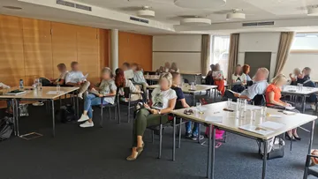 Personen, die in einem Konferenzraum sitzen.