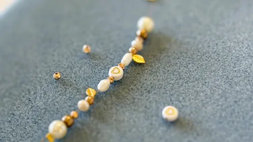 Beaded bracelet with heart and leaf charms.
