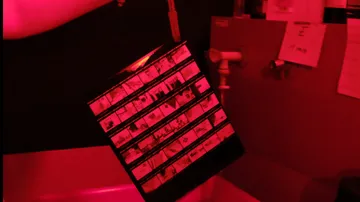 Film negatives being developed in darkroom.