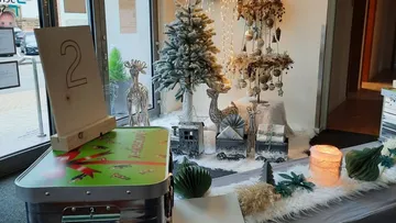 Weihnachtsdeko mit Baum, Rentieren, Lichtern drinnen.