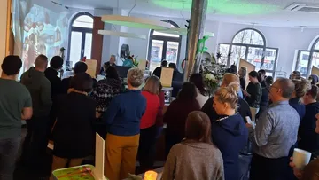Group of people gathered in a room watching presentation.