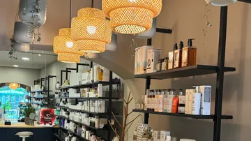 Cozy beauty store with shelves of products and woven lamps.