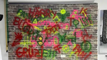 Graffiti auf Backsteinmauer mit bunten Buchstaben.