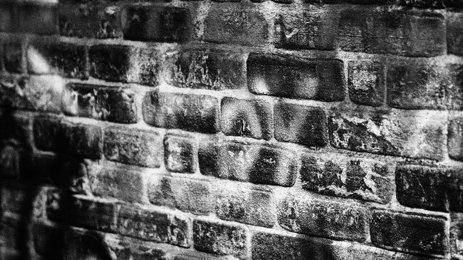 Alte Backsteinmauer mit Schattenmustern.