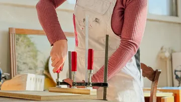 Person clamping wood pieces on table