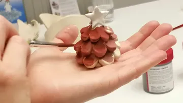 Crafting a clay Christmas tree ornament.