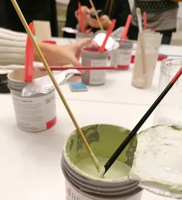 Open paint cans with brushes on table.