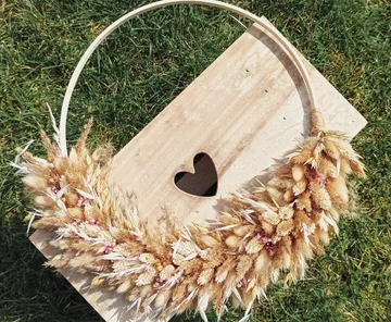 Blumenkranz auf Holz mit Herzausschnitt.