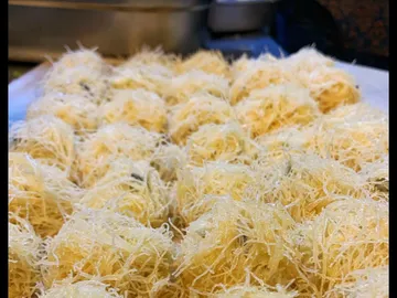 Gebackene Teigbällchen liegen auf einem Blech nebeneinander.
