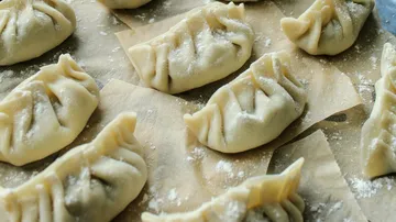 Rohe Knödel auf Pergamentpapier.