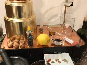 Copper still with ingredients such as lemon and nuts.