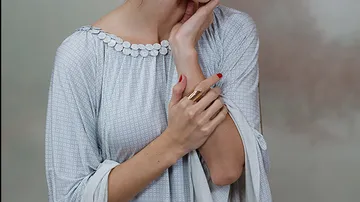 Person in gray dress with patterned texture.