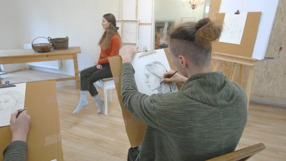Künstler, die im Studio ein sitzendes Modell skizzieren.