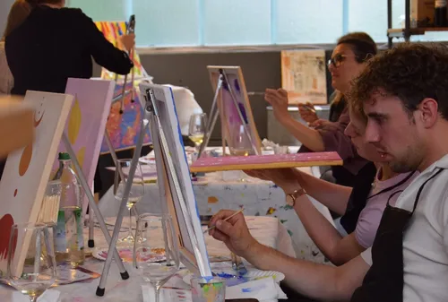 People painting on canvases in a studio