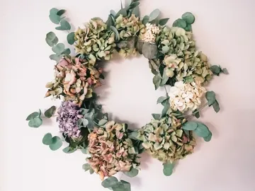 Dried flower wreath hanging on a wall, decorative accent