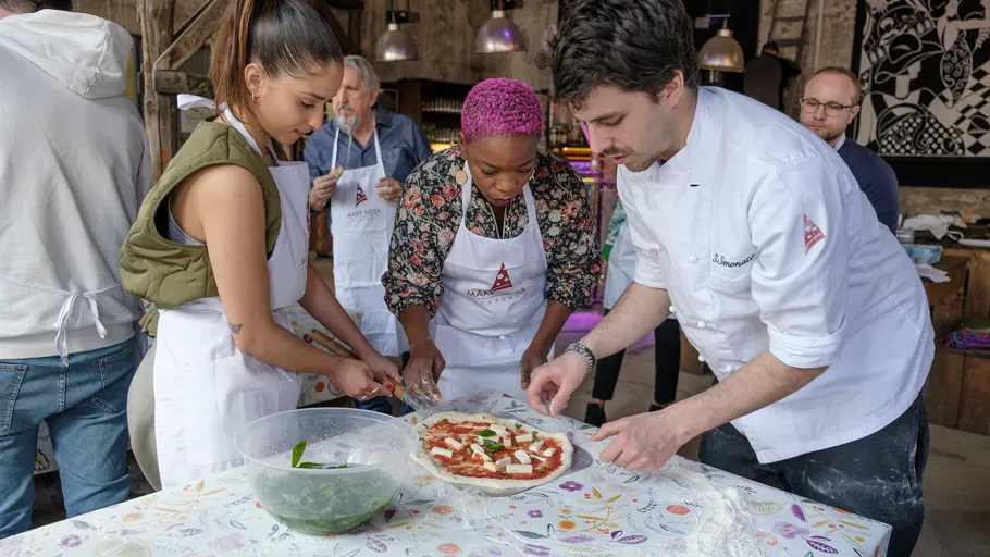 People making pizza at a cooking class.