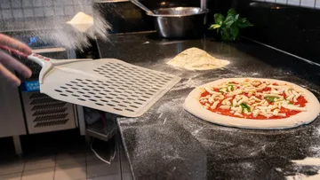Pizzazubereitung, mit Mehl bestäubte Schale, Küchentheke.